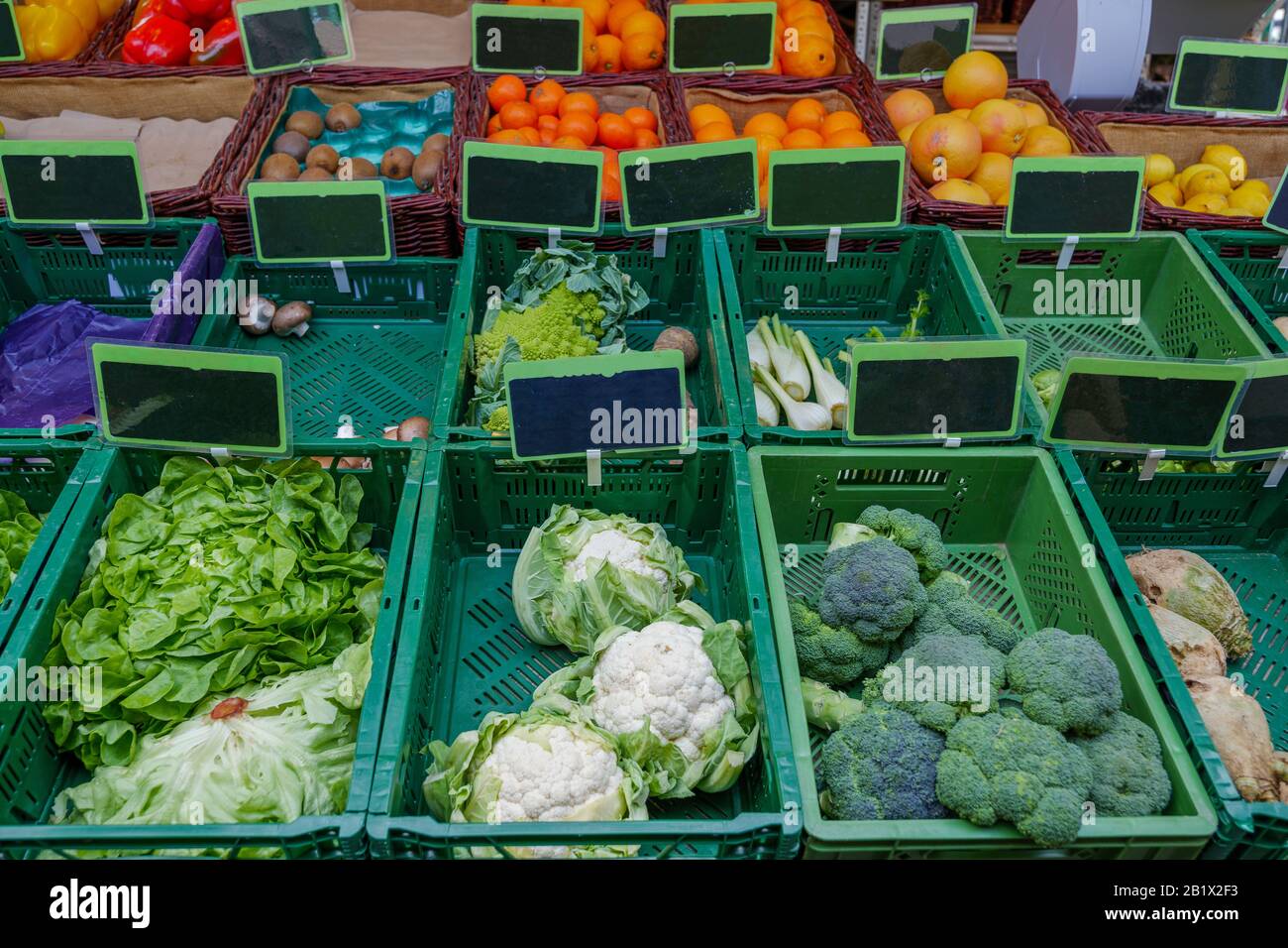 Vue de divers légumes et fruits vendre sur une rangée de paniers en  plastique vert devant un étalage à l'extérieur de l'épicerie sur le marché  des agriculteurs en plein air Photo Stock -