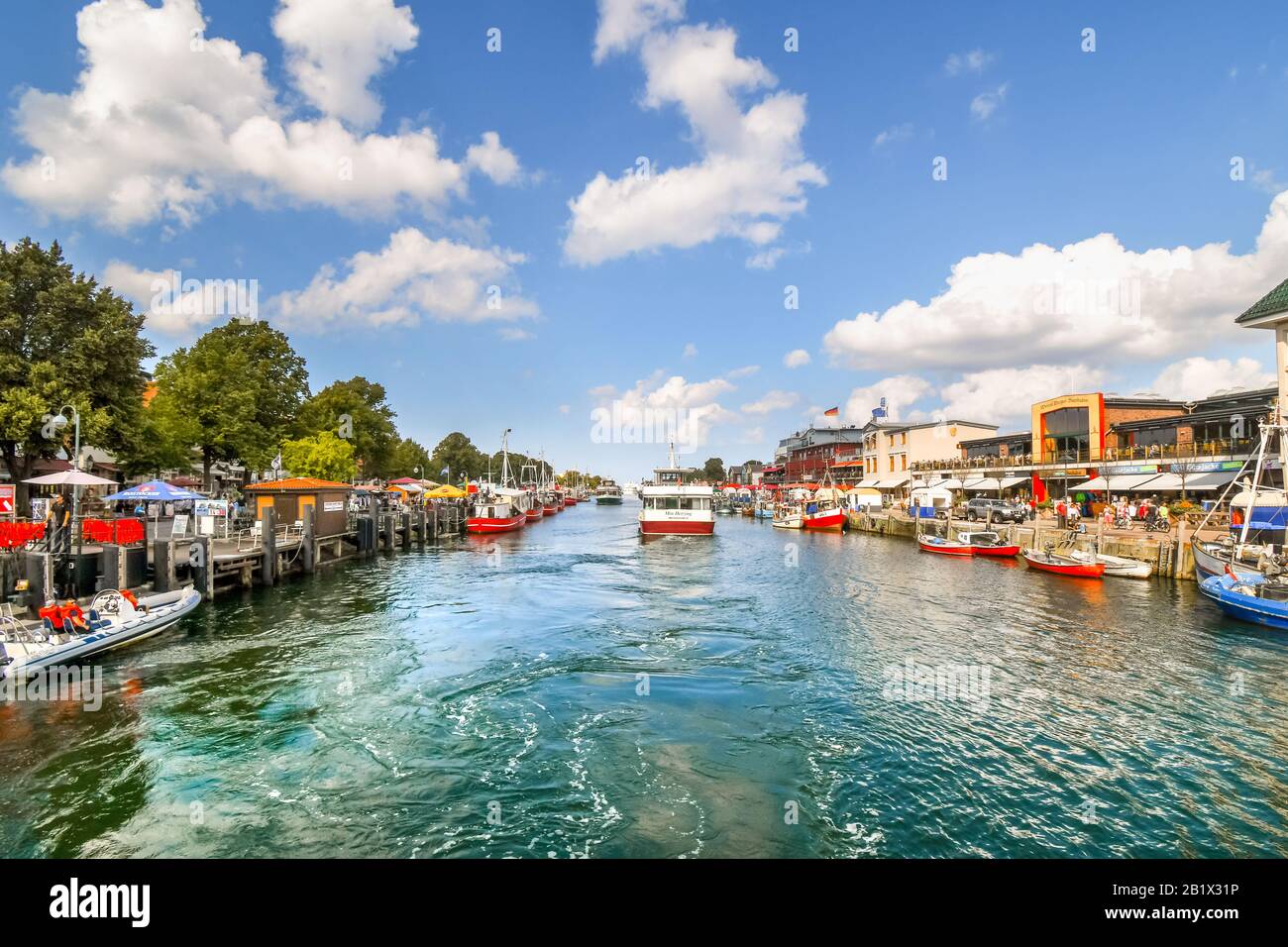 Un bateau de croisière touristique sur le canal Alter Strom dans le populaire village de pêcheurs de Warnemunde Allemagne sur la mer Baltique d'Europe du Nord. Banque D'Images