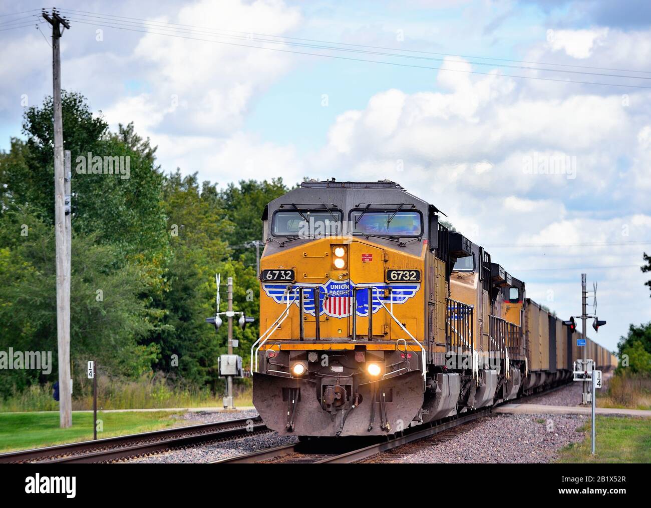 Malte, Illinois, États-Unis. Un train à charbon vide Union Pacific, dirigé par trois locomotives passant par un passage à niveau. Banque D'Images