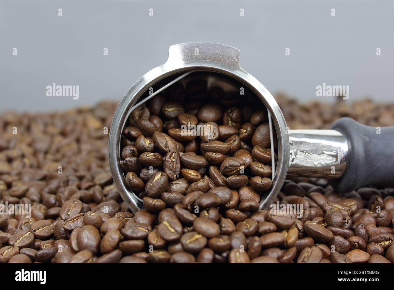 Poignée de groupe pleine de grains de café torréfiés foncés prêts à préparer une bière Banque D'Images