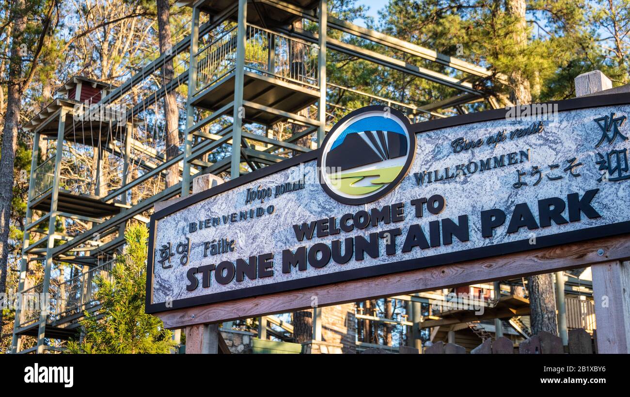 Signe de bienvenue au Stone Mountain Park à Atlanta, Géorgie avec parcours de cordes d'aventure en famille SkyHike en arrière-plan. (ÉTATS-UNIS) Banque D'Images