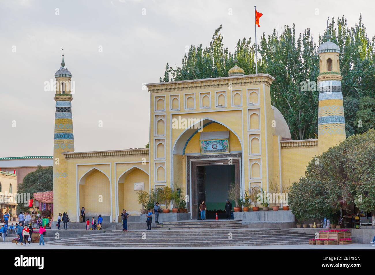 Vue Sur La Mosquée Id Kah. Un drapeau chinois est monté au sommet de la mosquée. ID Kah est la plus grande mosquée de Chine et située dans le centre-ville de Kashgar Banque D'Images