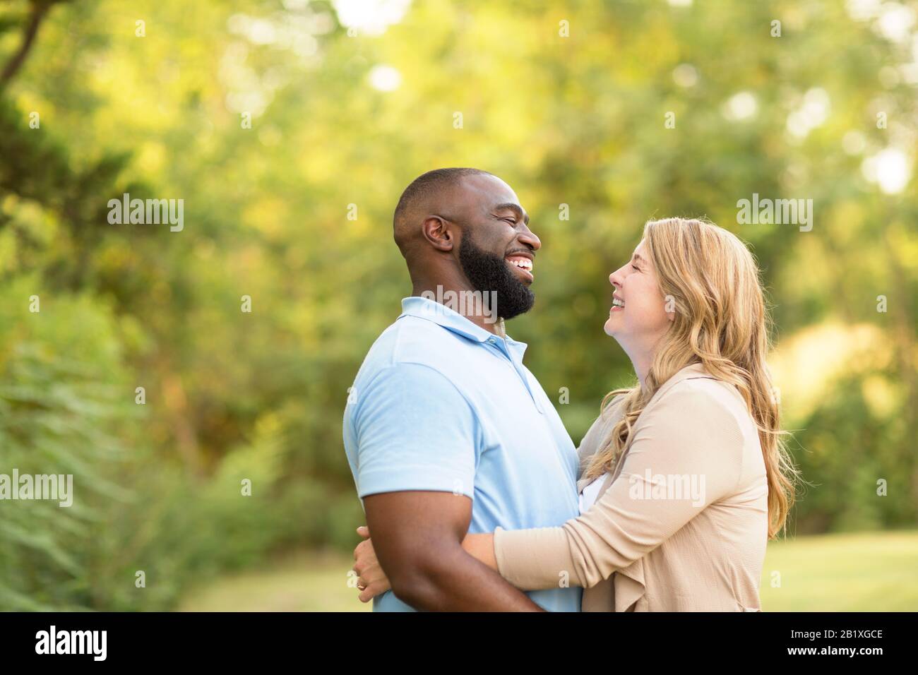 Aimer mixed race couple hugging and laughing. Banque D'Images