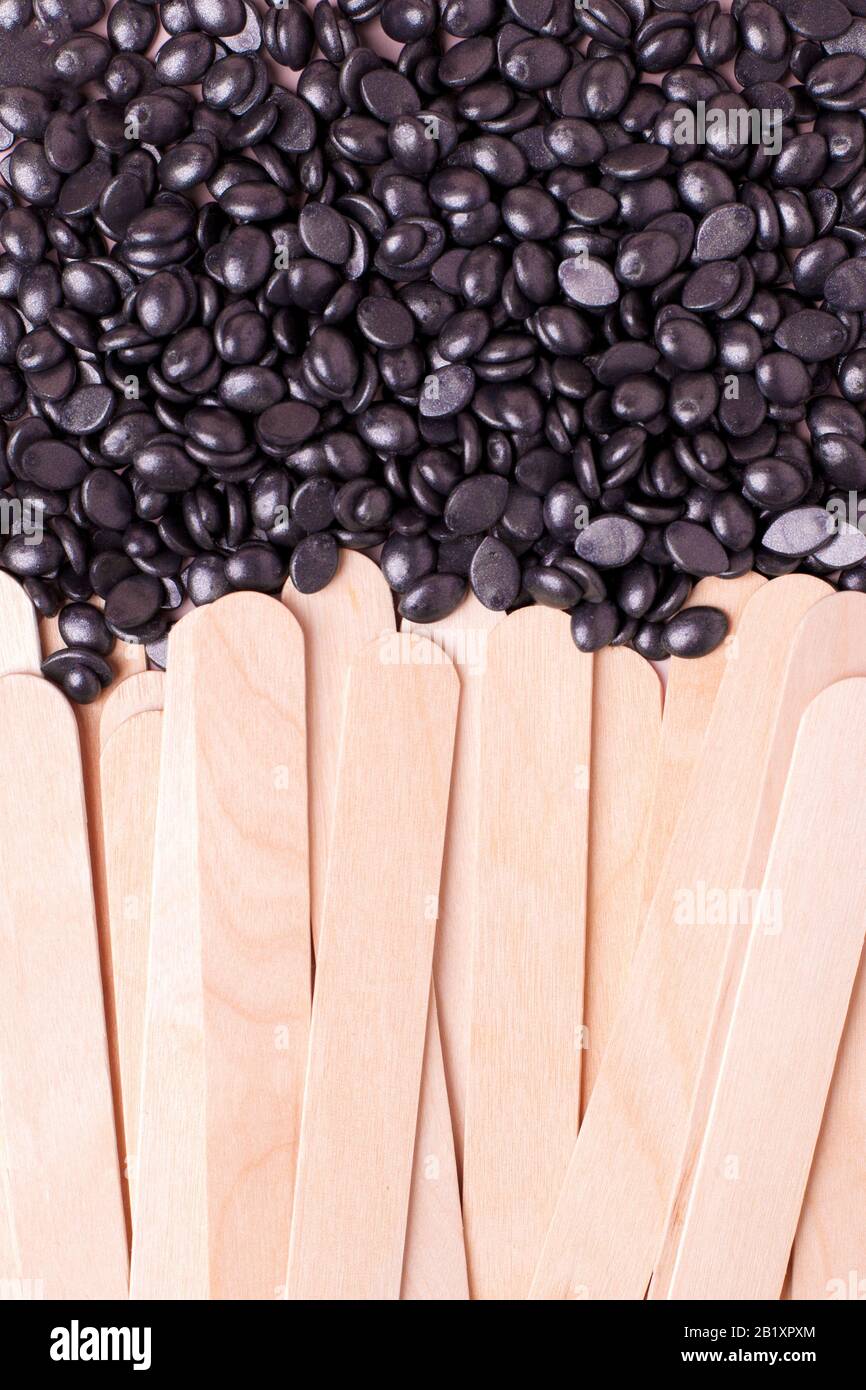 Cire en polymère de perle noire pour graines de grain et spatule en bois bâton pour la fermeture de l'épilation. Outils de concept od pour l'épilation, flyer, bannière, coupon, distante, Banque D'Images