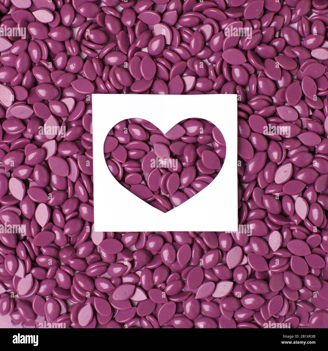 Perruque dépilatoire Hard Wax Beans couleur violette et coeur, concept de soins du corps de la peau, industrie de beauté, salon de spa, hait enlever des matériaux. réduction bann Banque D'Images
