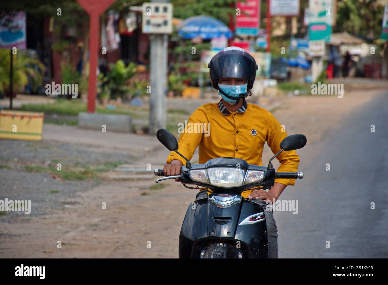 Jeune homme avec masque médical à moto dans les rues de Phnom Penh Photo  Stock - Alamy