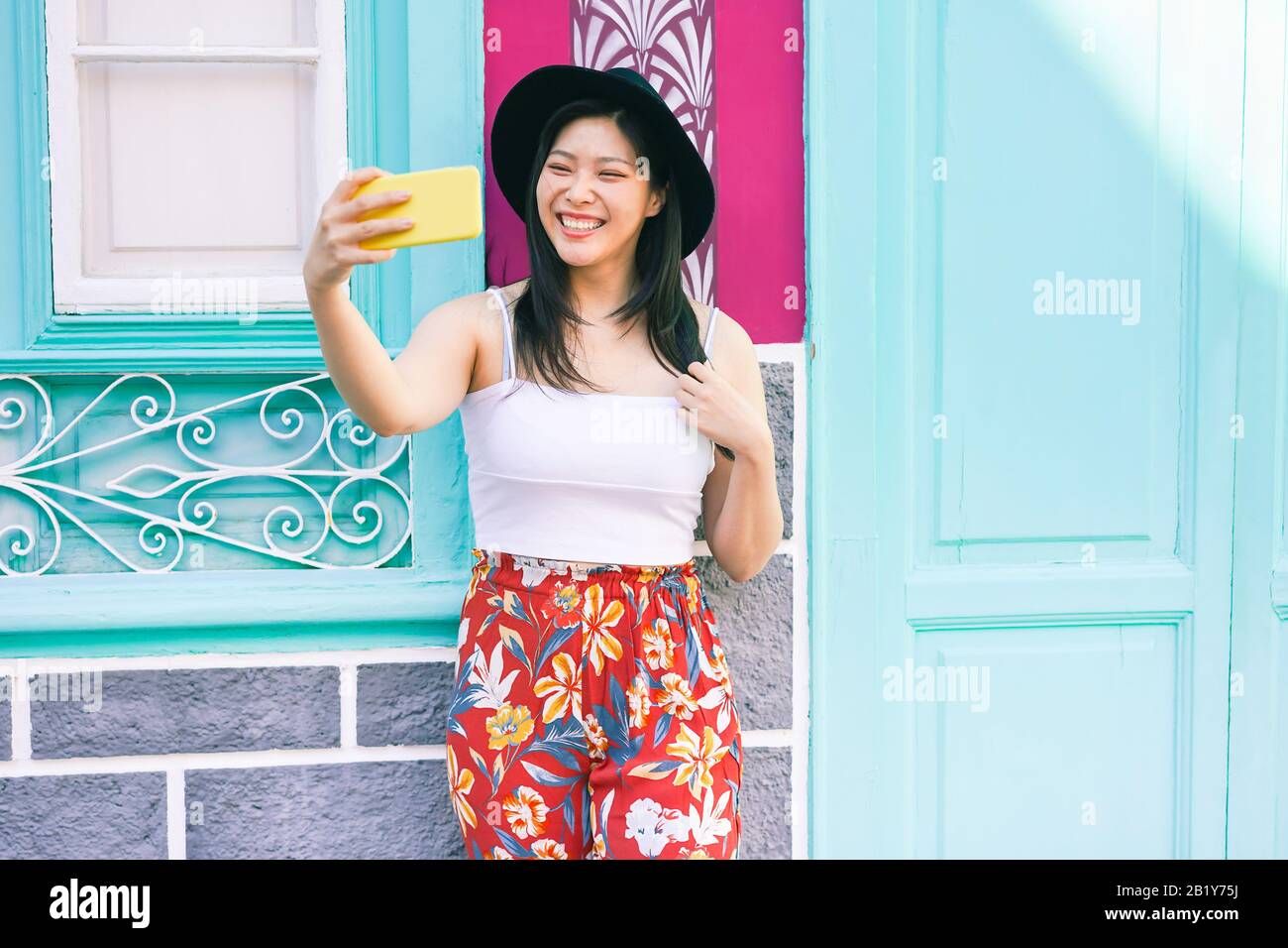 Une femme influente en Asie qui raconte l'histoire d'un réseau social avec un appareil photo pour smartphone : Une jeune fille Heureuse qui s'amuse avec les nouvelles technologies de tendances : mode et m Banque D'Images