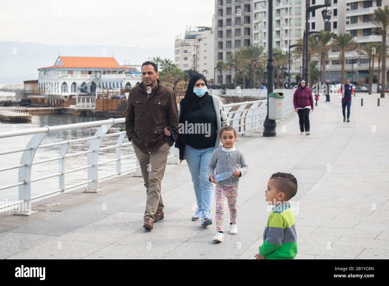 Beyrouth, Liban. 28 février 2020: Une femme marchant avec sa famille le long du front de mer de Beyrouth portant un masque protecteur contre le coronavirus covid 19. Le ministère des transports a annoncé que le Liban a interrompu les vols pour les non-résidents en provenance de pays aux flambées de coronavirus, notamment la Chine, l'Iran, l'Italie et la Corée du Sud. Crédit: Amer ghazzal/Alay Live News Banque D'Images