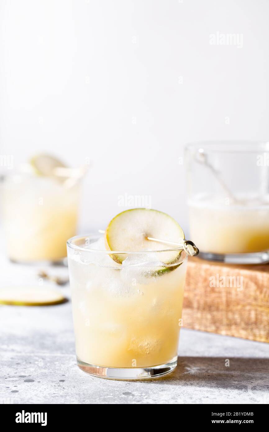 Un petit verre de mocktail ou de cocktail rafraîchissant à base de soda de poire sur fond de béton gris. Boisson estivale sans alcool. Mise au point sélective Banque D'Images