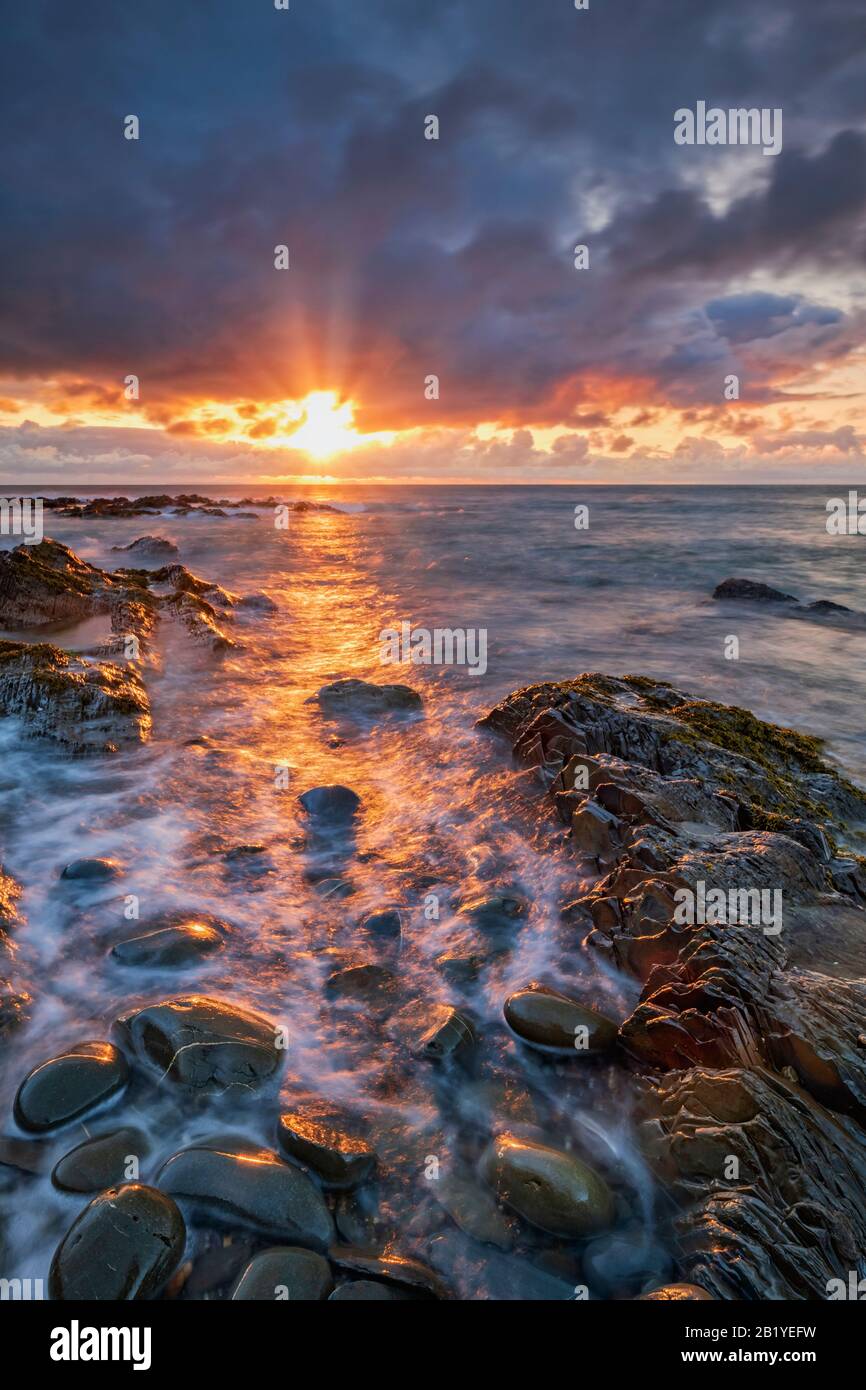 Coucher de soleil romantique et spectaculaire sur le nord du Devon, plage, côte, littoral, vie costale, magnifique, littoral, rochers, réflexions, galets, nuages, Royaume-Uni Banque D'Images