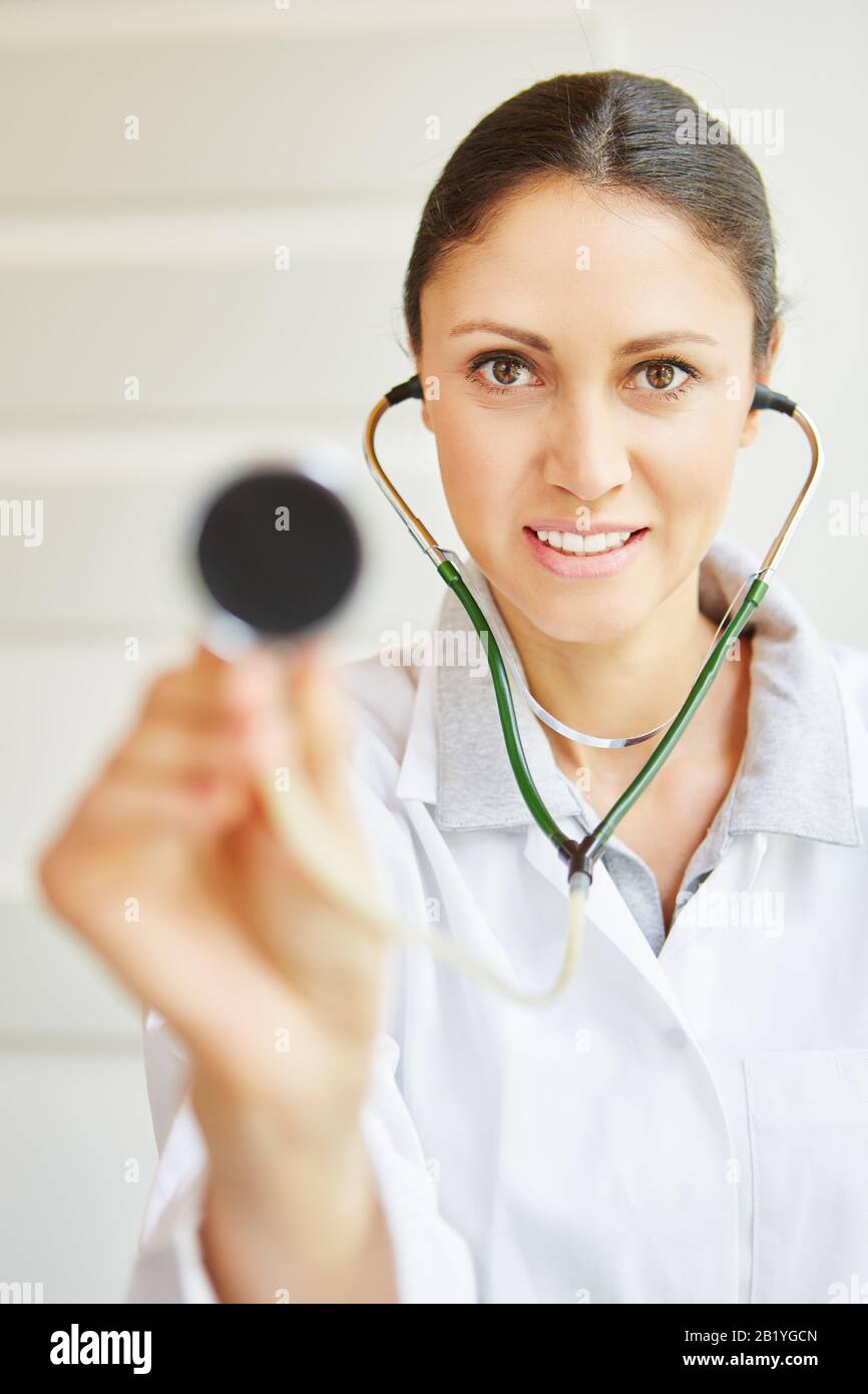 Femme médecin avec stéthoscope à l'écoute en consultation Banque D'Images