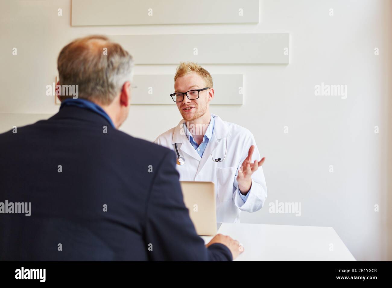 Le médecin parle à un patient à son bureau Banque D'Images