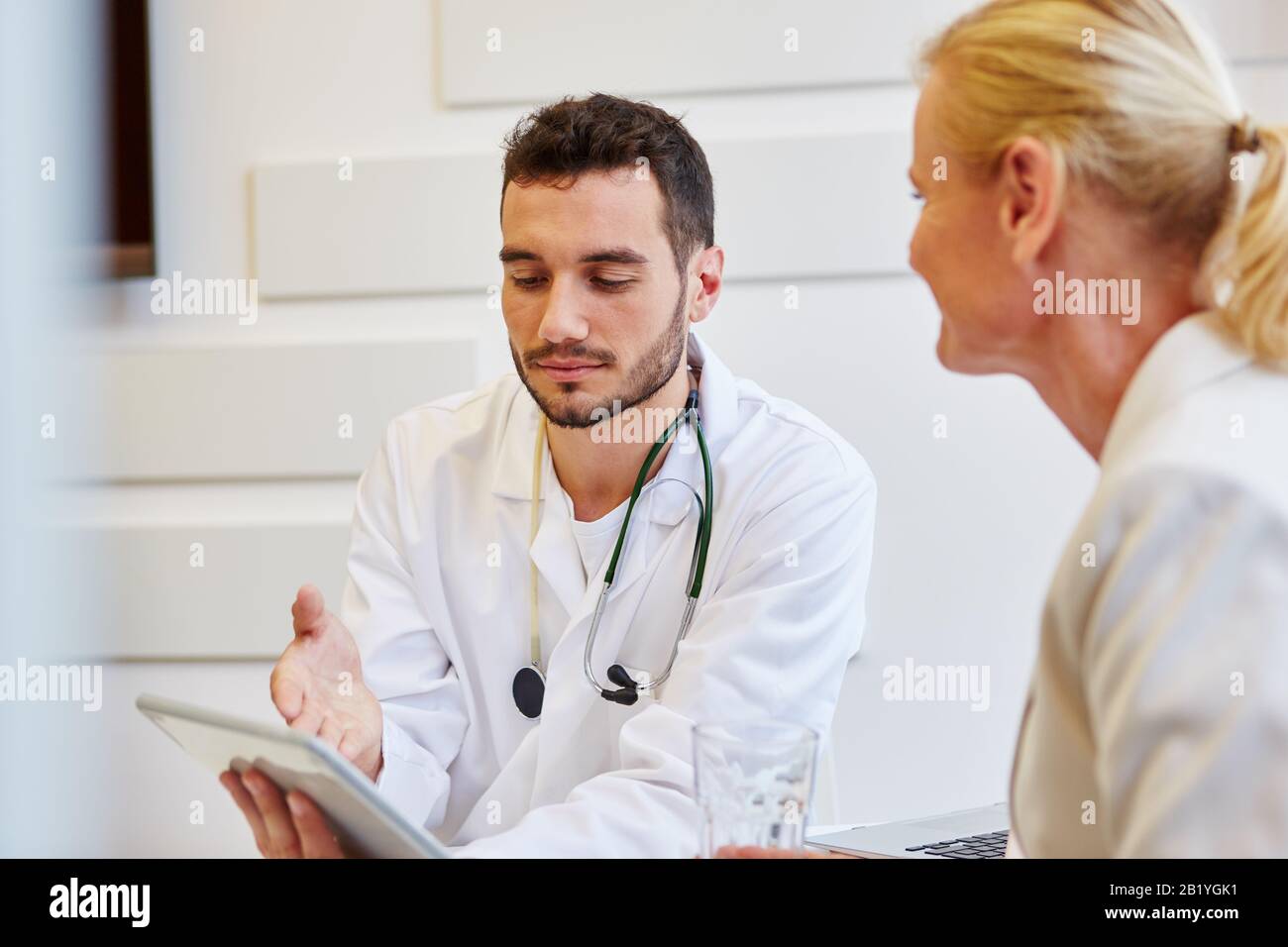 Médecin avec patient et tablette PC pendant ses heures de bureau Banque D'Images