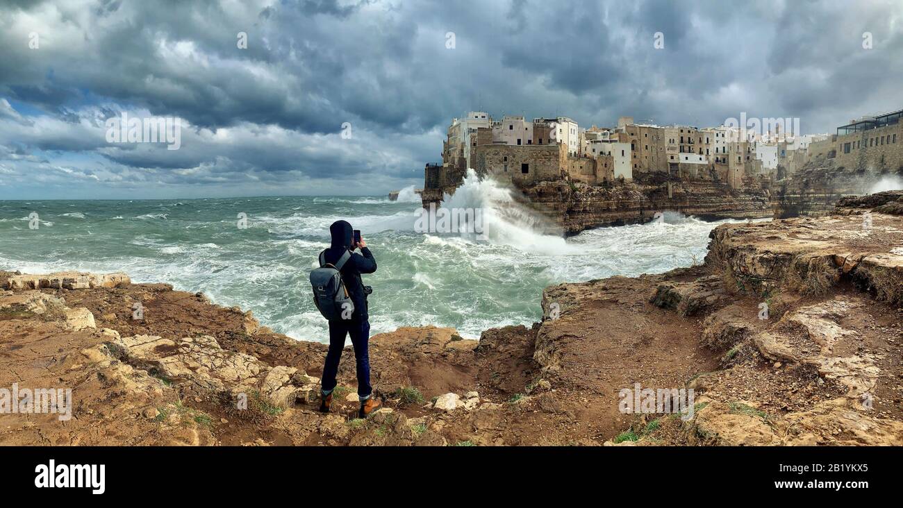 Photographe prenant photo d'une mer de tempête à Polignano a Mare, Italie Banque D'Images