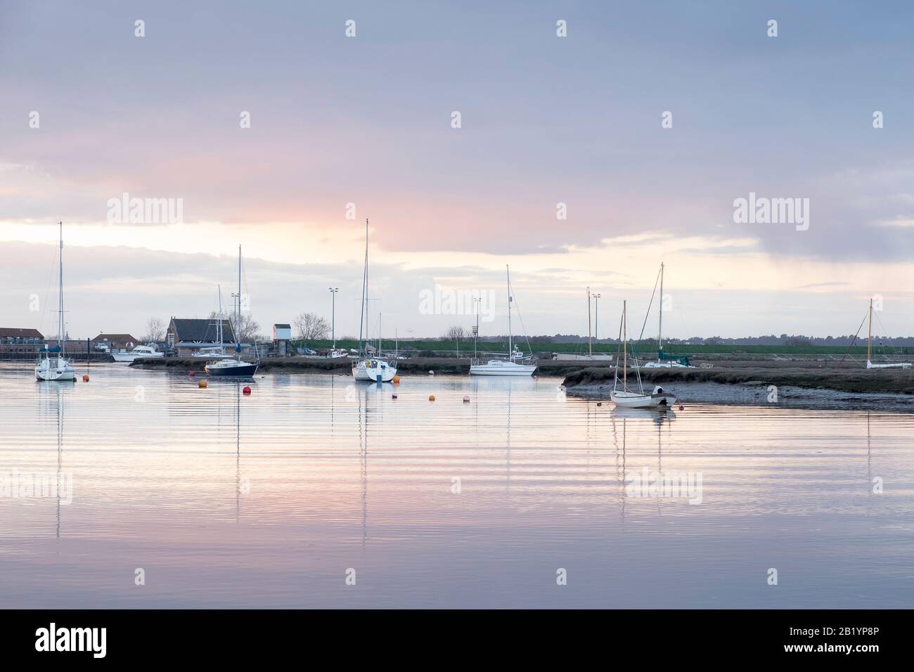 Scène tranquille de bateaux à l'ancre dans le port de Wells au coucher du soleil. Banque D'Images