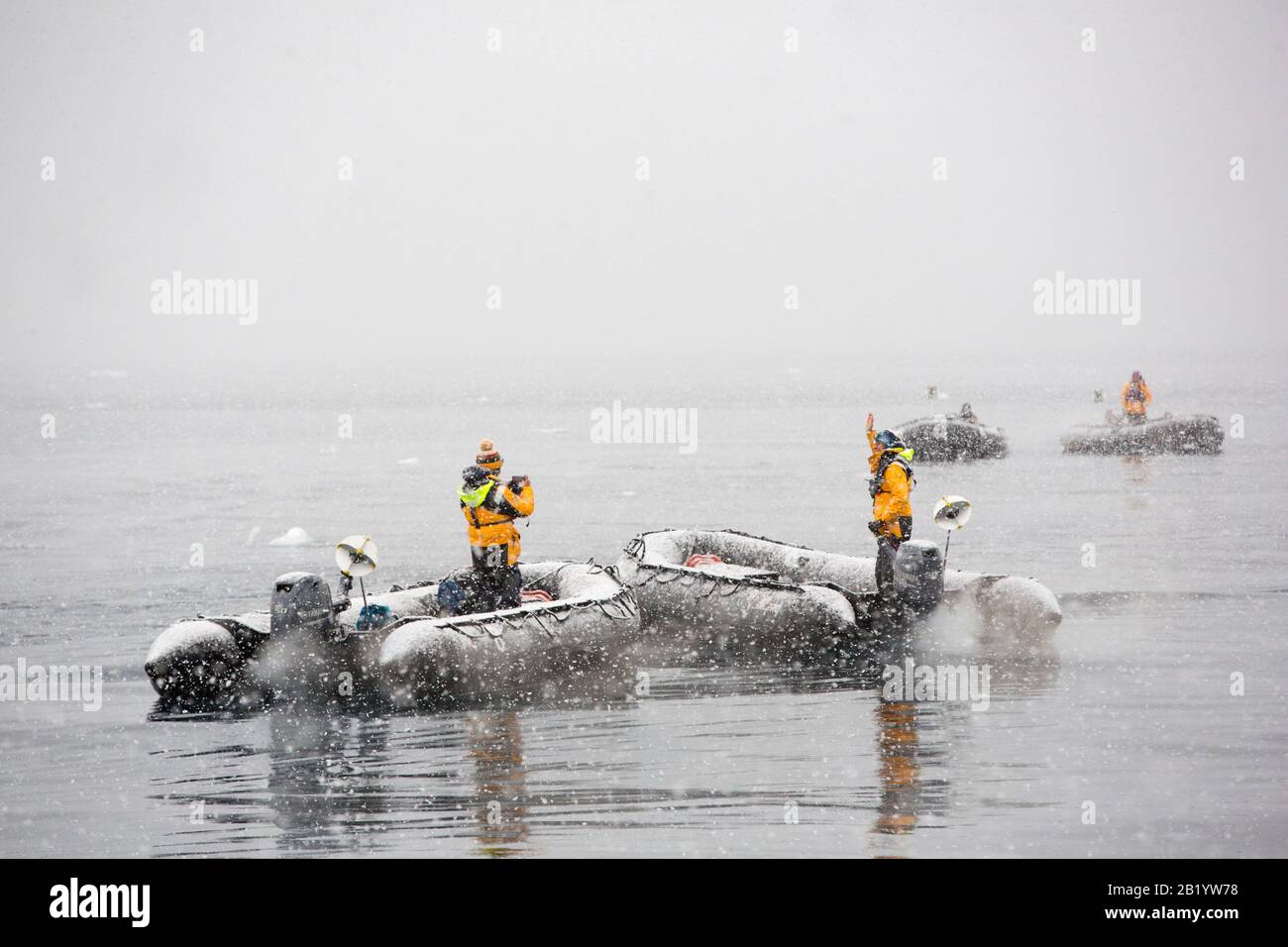 Zodiacs d'un navire de croisière d'expédition dans la neige épaisse de la baie Fournier, en Antarctique. Le zodiaque a un réflecteur radar sur le dos pour que le radar du navire puisse Banque D'Images