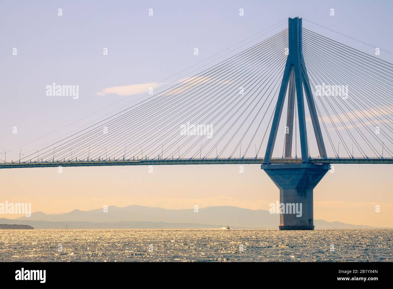 Grèce. Pont Rion Antirion. Haut pylon du pont suspendu par câble au-dessus du golfe de Corinthe et du bateau à moteur en journée ensoleillée Banque D'Images