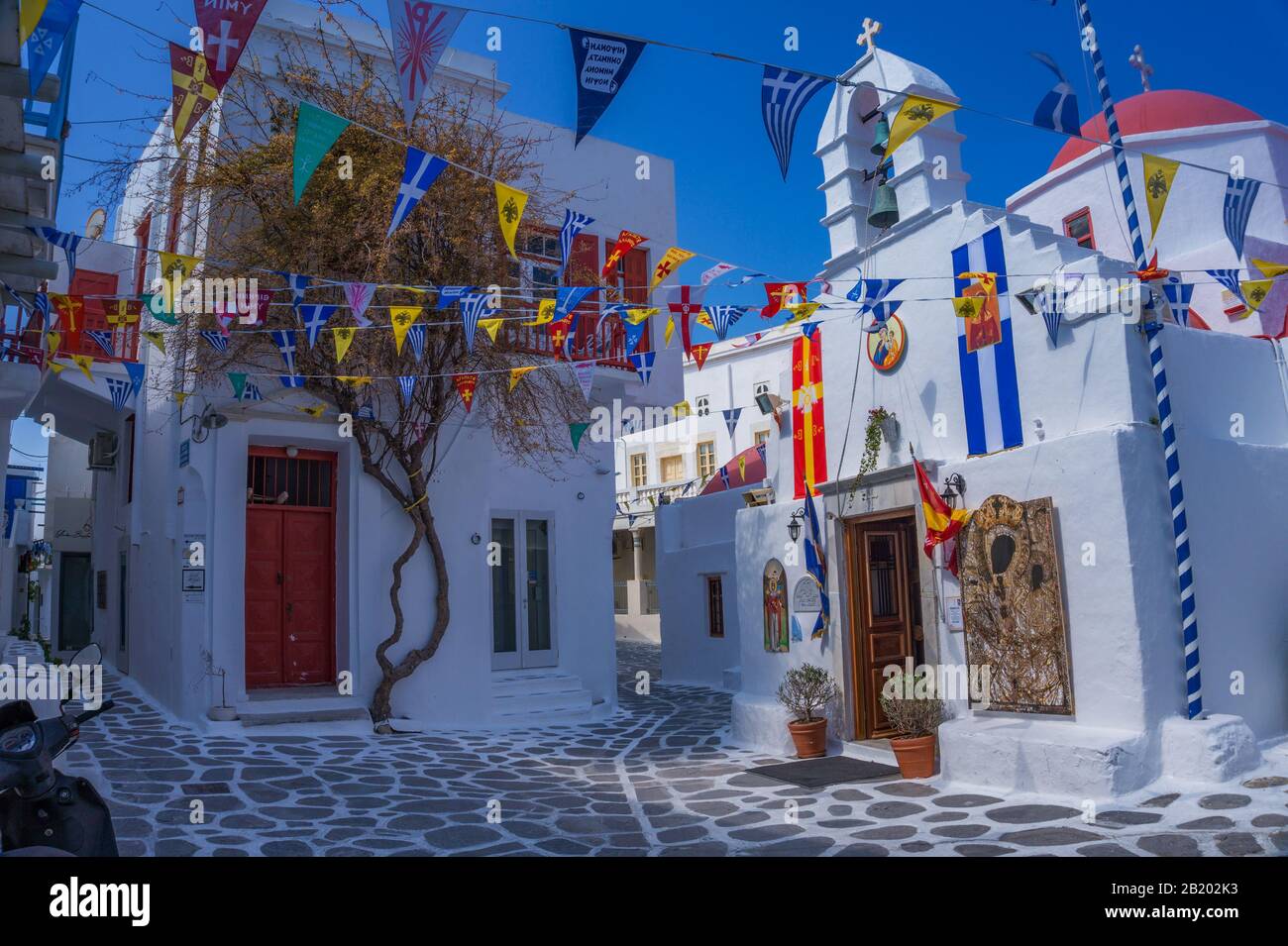 Rue Pavée étroite sur l'île de Mykonos avec bâtiments architecturaux traditionnels avec maisons, boutiques et églises pendant une saison non touristique. Banque D'Images