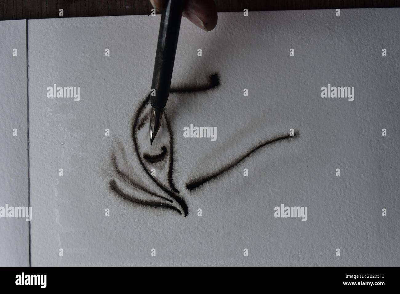 Séquence de dessin avec stylo immergé dans l'encre de l'Inde sur du papier d'aquarelle humide avec propagation de l'encre. Banque D'Images