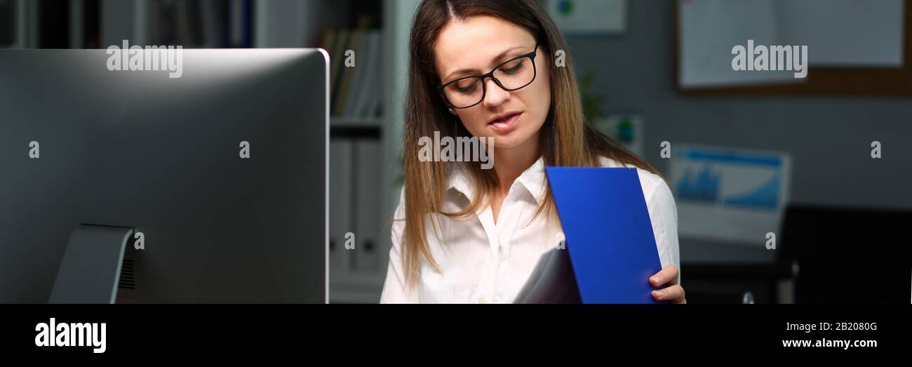 Femme a ouvert le dossier avec des documents les examine Banque D'Images