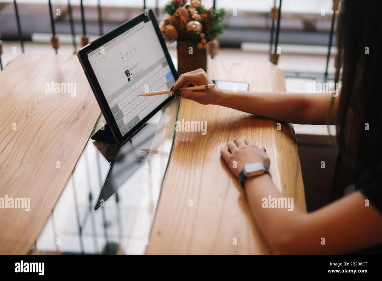Gros plan sur les mains d'une jeune fille non reconnaissable qui écrit sur une tablette numérique. Banque D'Images