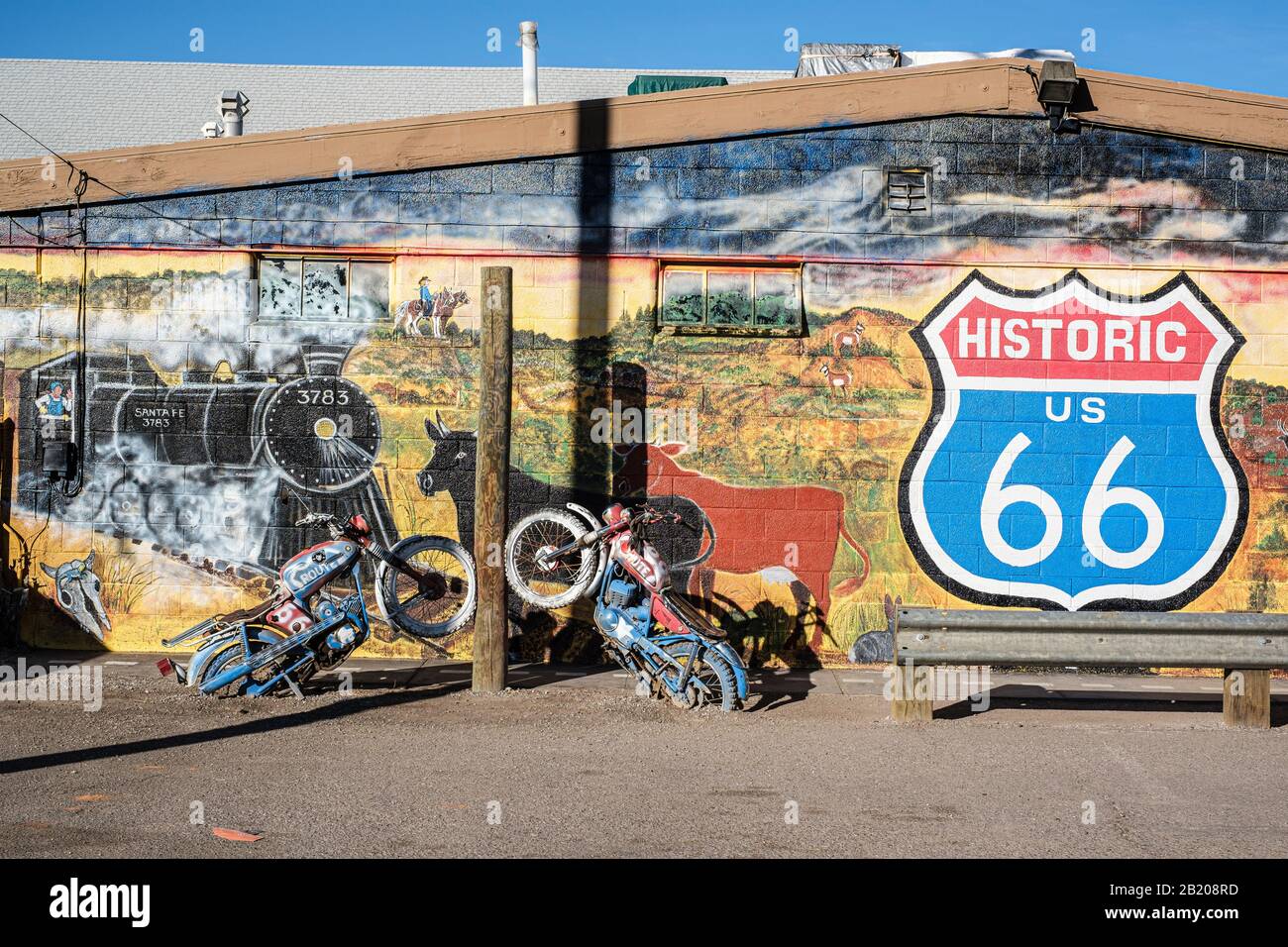 Extérieur du chariot de cuivre, Seligman, Arizona, États-Unis. Panneau historique de la route 66 et fresque murale pittoresque sur le mur avec motos en béton Banque D'Images