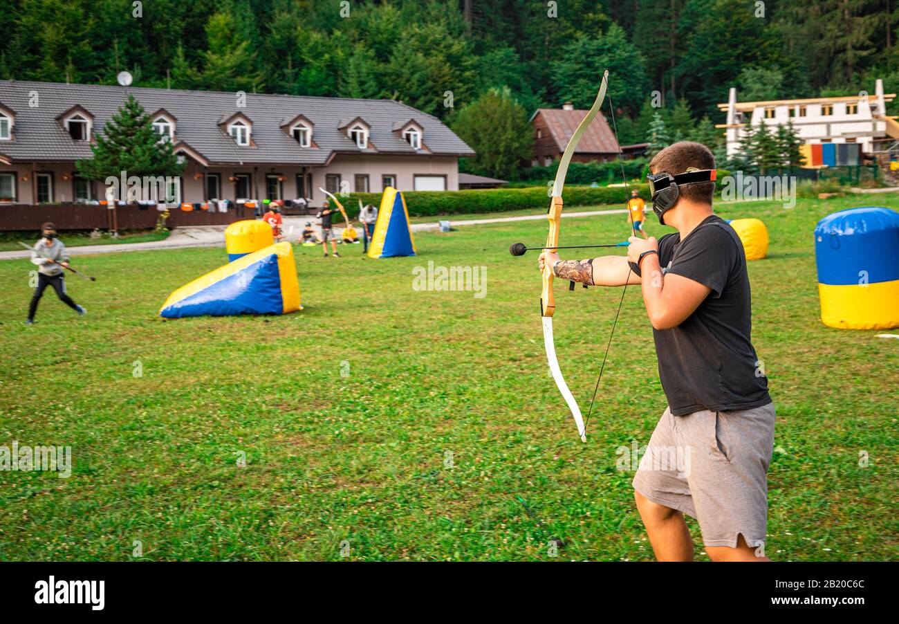 Adolescent jouant au tir à l'arc pendant l'été Banque D'Images