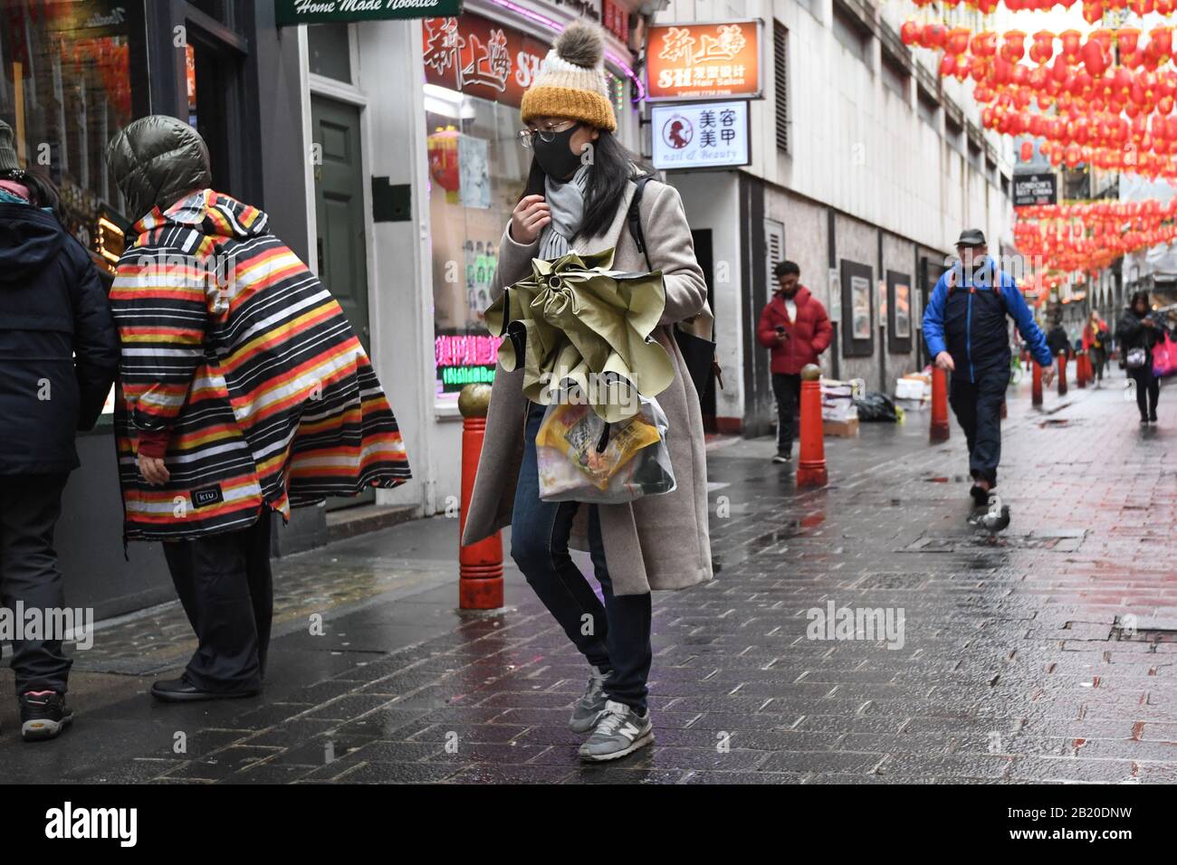 Une femme portant un masque de visage dans China Town, Leicester Square, Londres, comme le premier cas de coronavirus a été confirmé au Pays de Galles et deux autres ont été identifiés en Angleterre - portant le nombre total au Royaume-Uni à 19. Banque D'Images