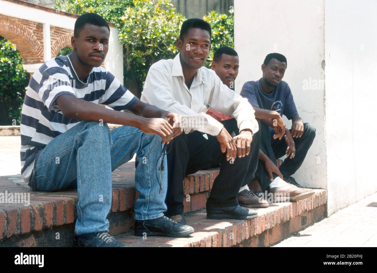 Quatre hommes assis sur quelques marches en République dominicaine. Banque D'Images