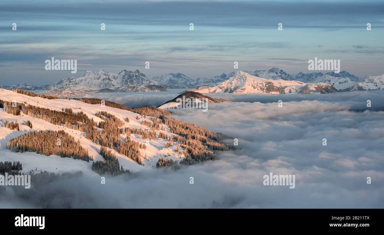 Panorama sur la montagne avec Kitzbuehler Horn et Loferer Steinbergen en hiver, les pics de montagne au-dessus de la couverture nuageuse dans la lumière du soir, SkiWelt Wilder Banque D'Images