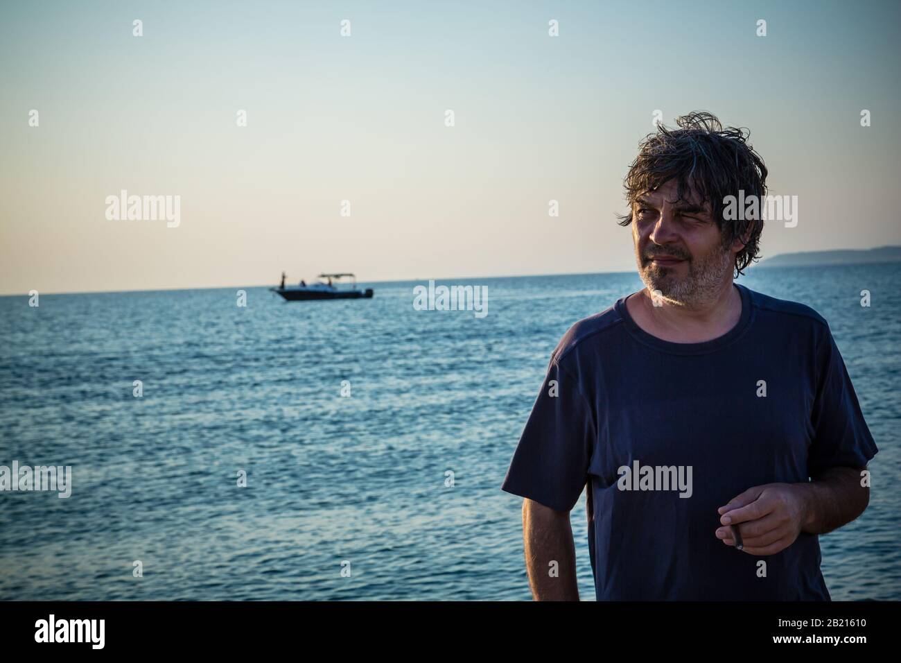 Bel homme avec un look lointain / Portrait de bon homme d'âge moyen sur la plage pendant les couchers de soleil Banque D'Images