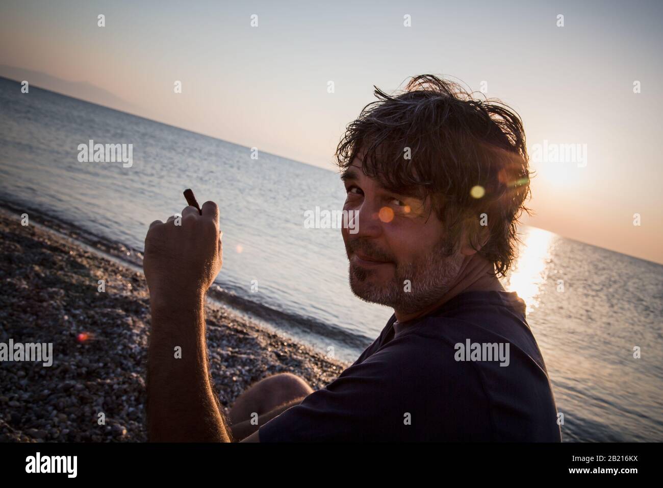 Portrait de bon homme d'âge moyen avec un cigare / coucher de soleil. Gros plan Banque D'Images