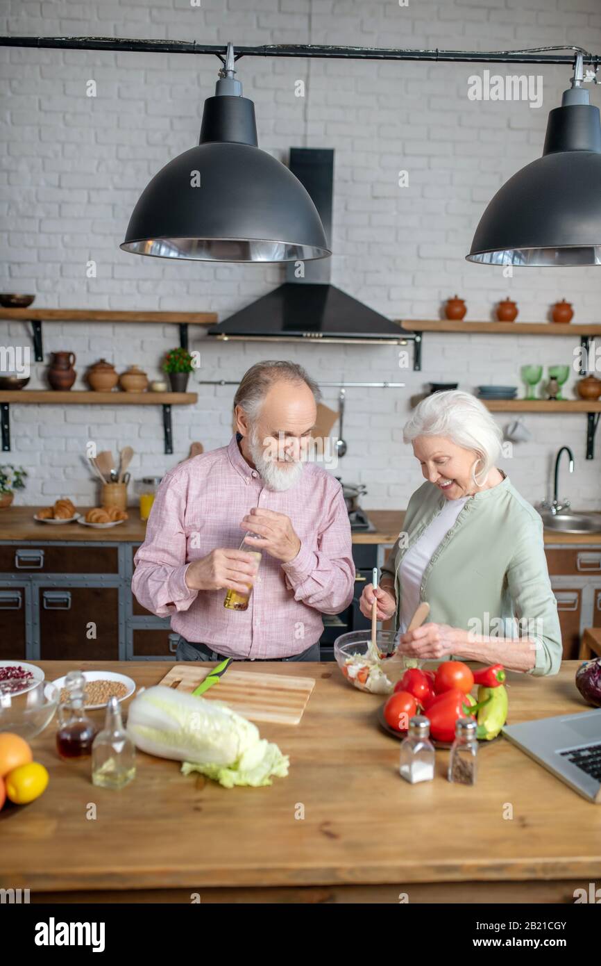 Couple d'aînés qui font une salade pour un dîner ensemble Banque D'Images