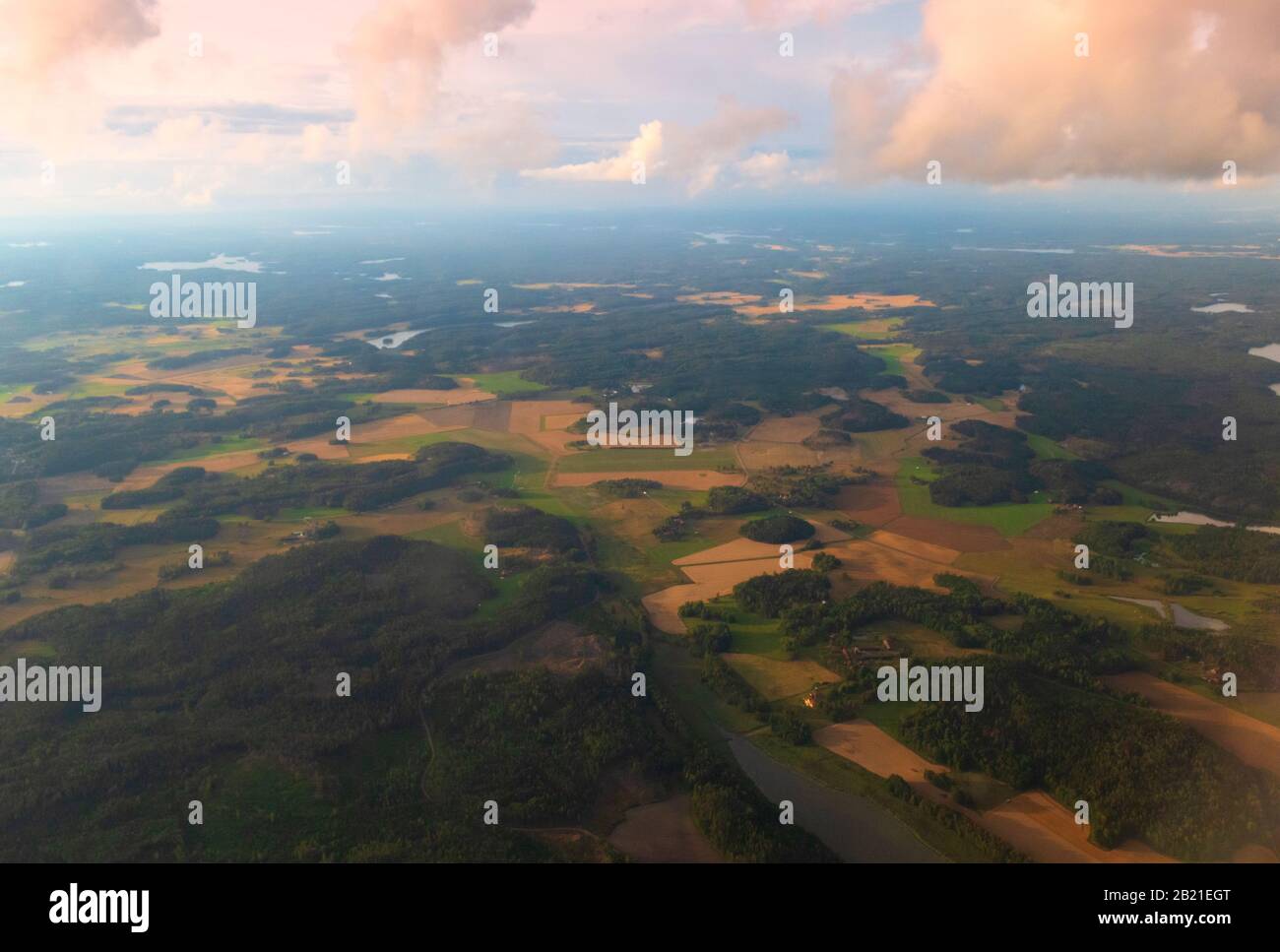 Vue aérienne de la campagne suédoise avec les terres agricoles, les forêts vertes et les champs de blé vus de l'avion volant à l'aéroport de Scavsta après la tempête estivale Banque D'Images