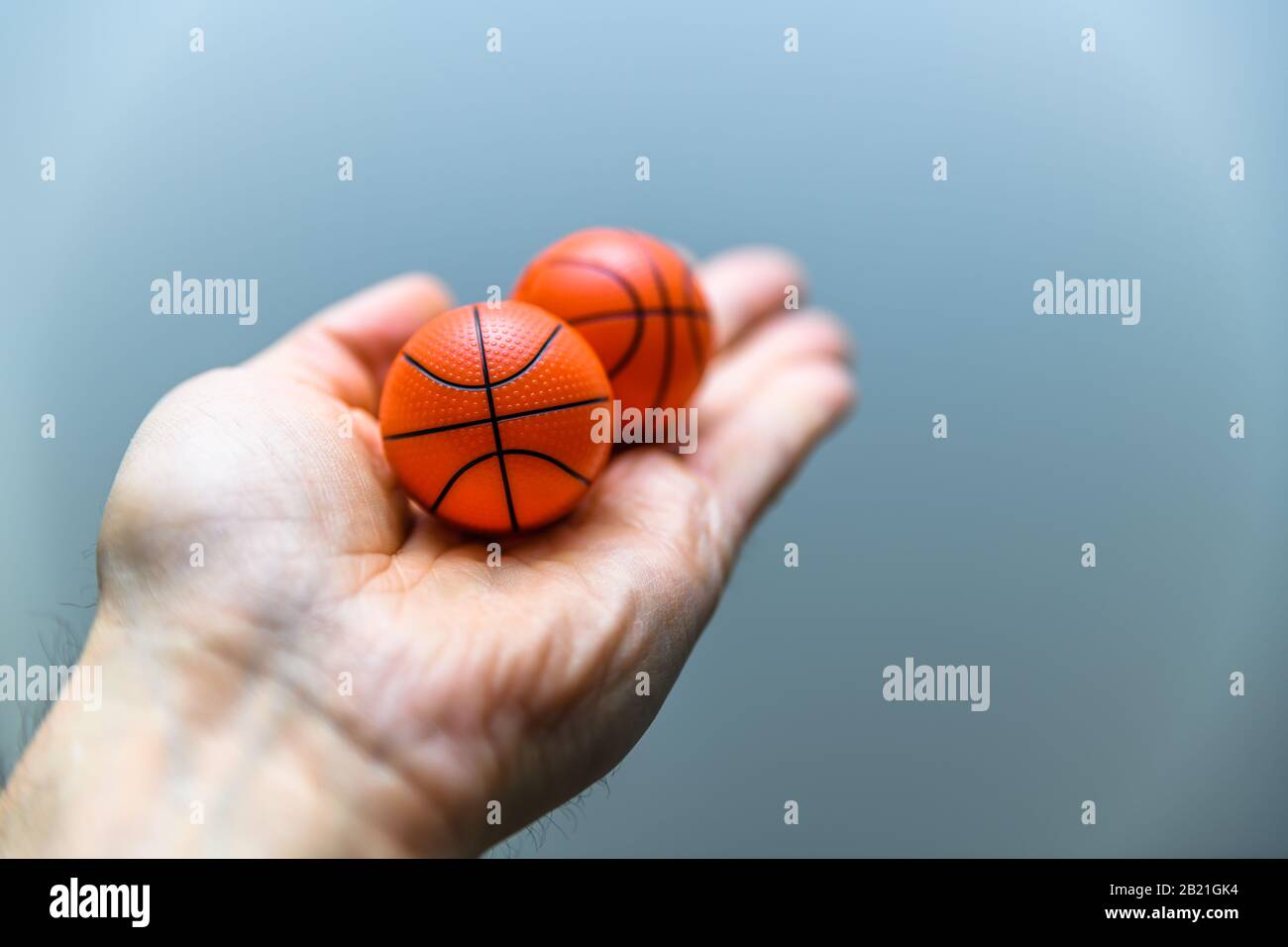 Main tenant deux boules orange de basket-ball comme des boules de désodorisant de chaussure.concept pour éviter l'odeur désagréable ou l'odeur des chaussures d'entraînement dans un style de vie actif. Banque D'Images