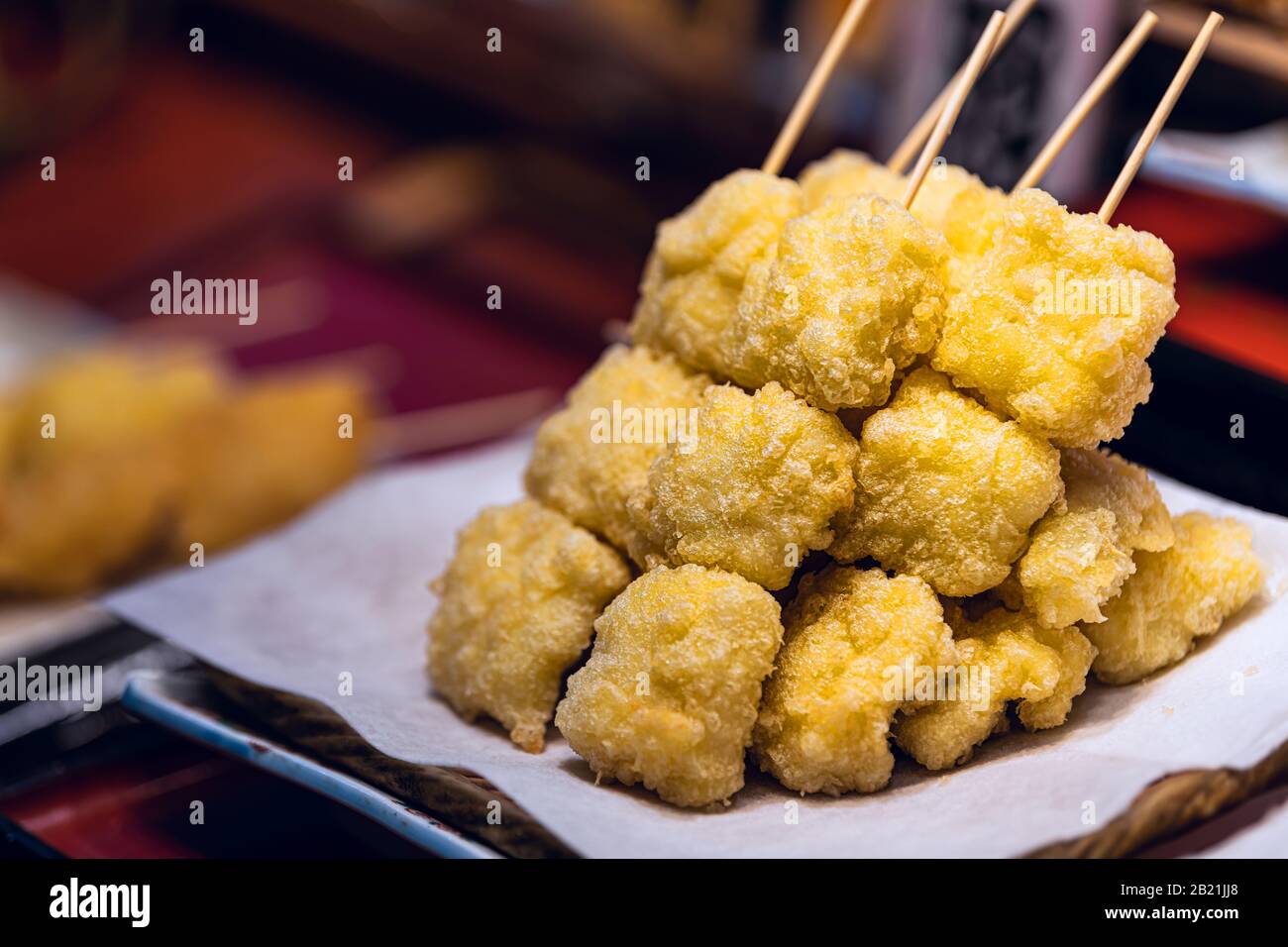 Présentation d'une collation tempura avec croûte de lecture sur brochette dans la cuisine traditionnelle japonaise de rue sur le marché de Nishiki Banque D'Images