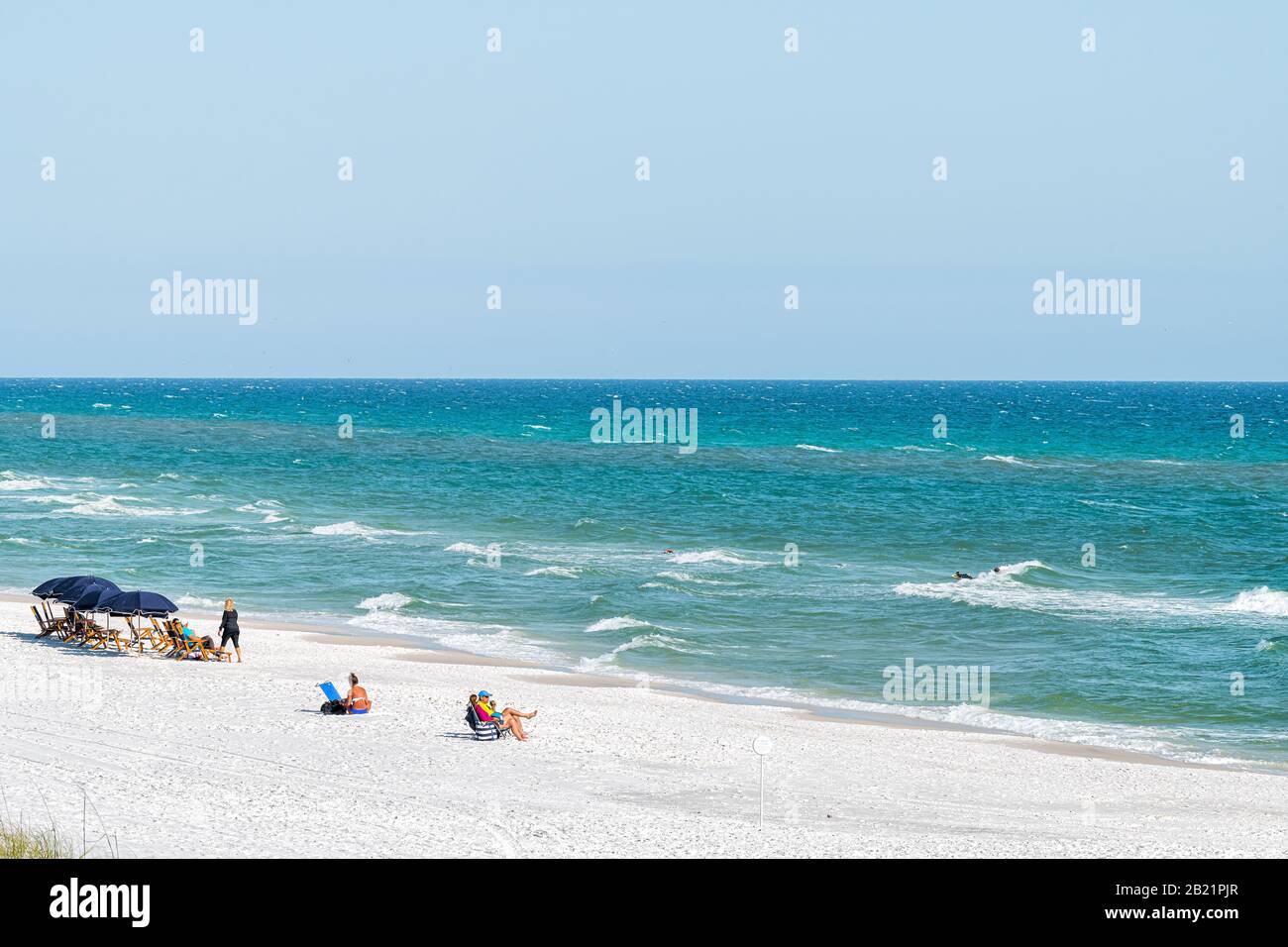 Seaside, États-Unis - 25 avril 2018: Plage pendant la journée ensoleillée dans le village de Floride avec vue à angle élevé des personnes sur la rive et l'horizon des vagues Banque D'Images