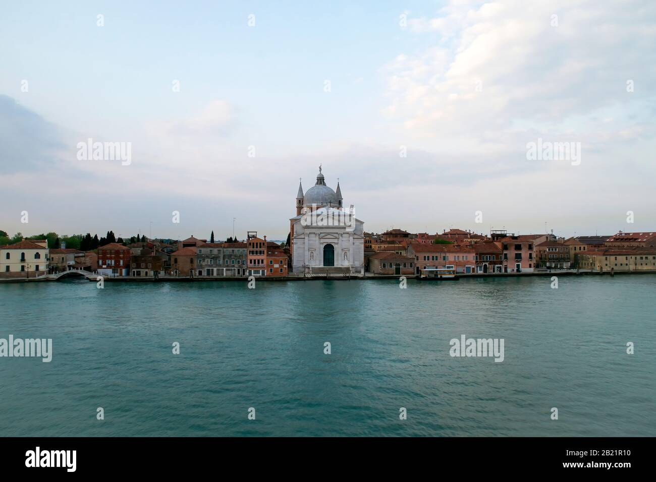 Maisons, commerces, bateaux, ponts et la Basilique ou Chiesa Del Santissimo Redentore vu du canal Giudecca. Lumière tôt le matin. Banque D'Images