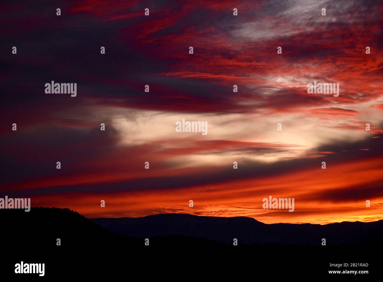 Nuages tourbillonnant menant à une silhouette de montagne, Arizona US Banque D'Images