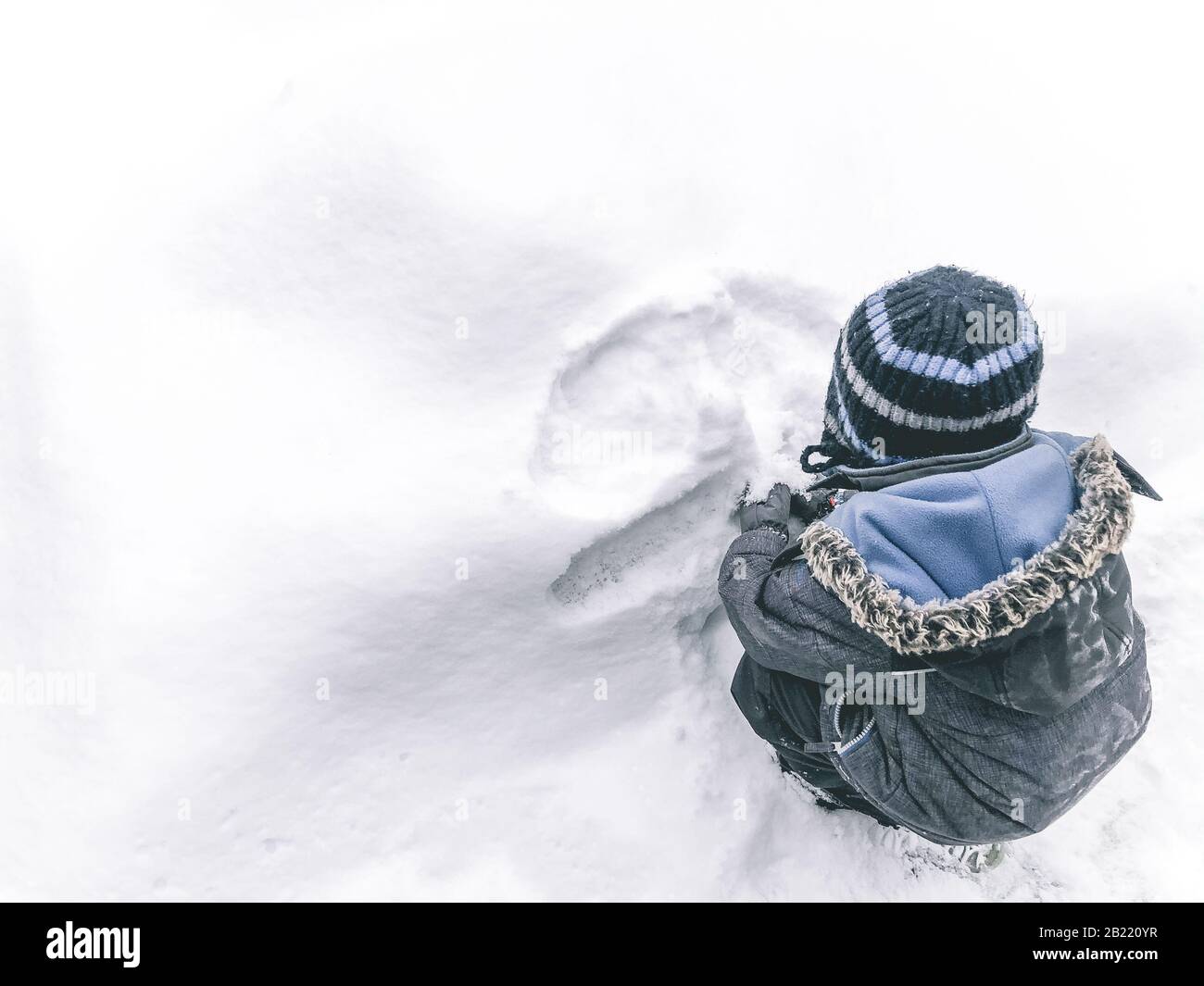 Jeune enfant jouant dans la neige, la neige blanche, l'enfant en vêtements d'hiver Banque D'Images