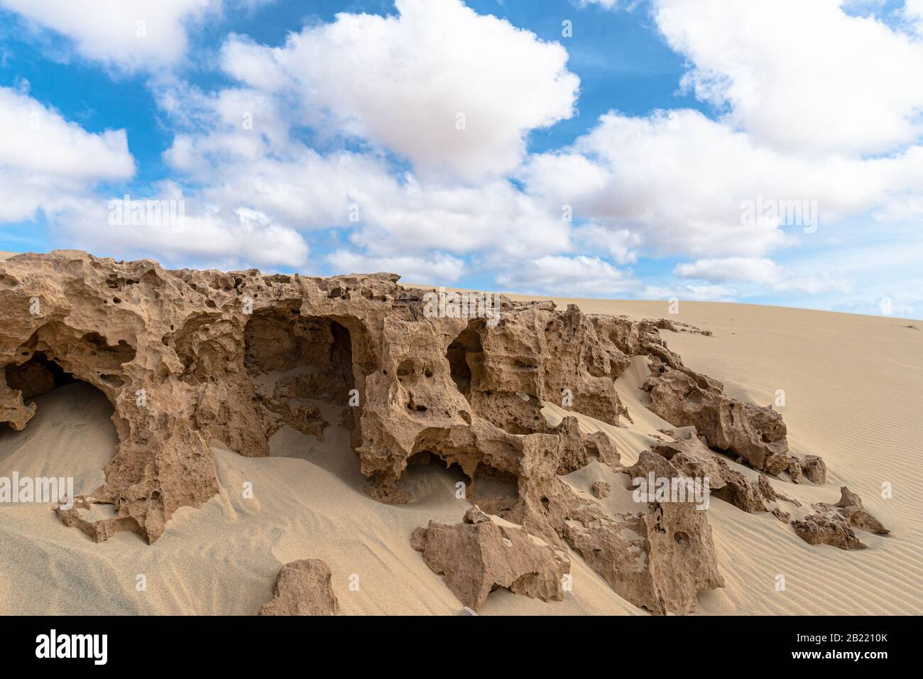 Désert de sable et rochers sous le ciel nuageux Banque D'Images