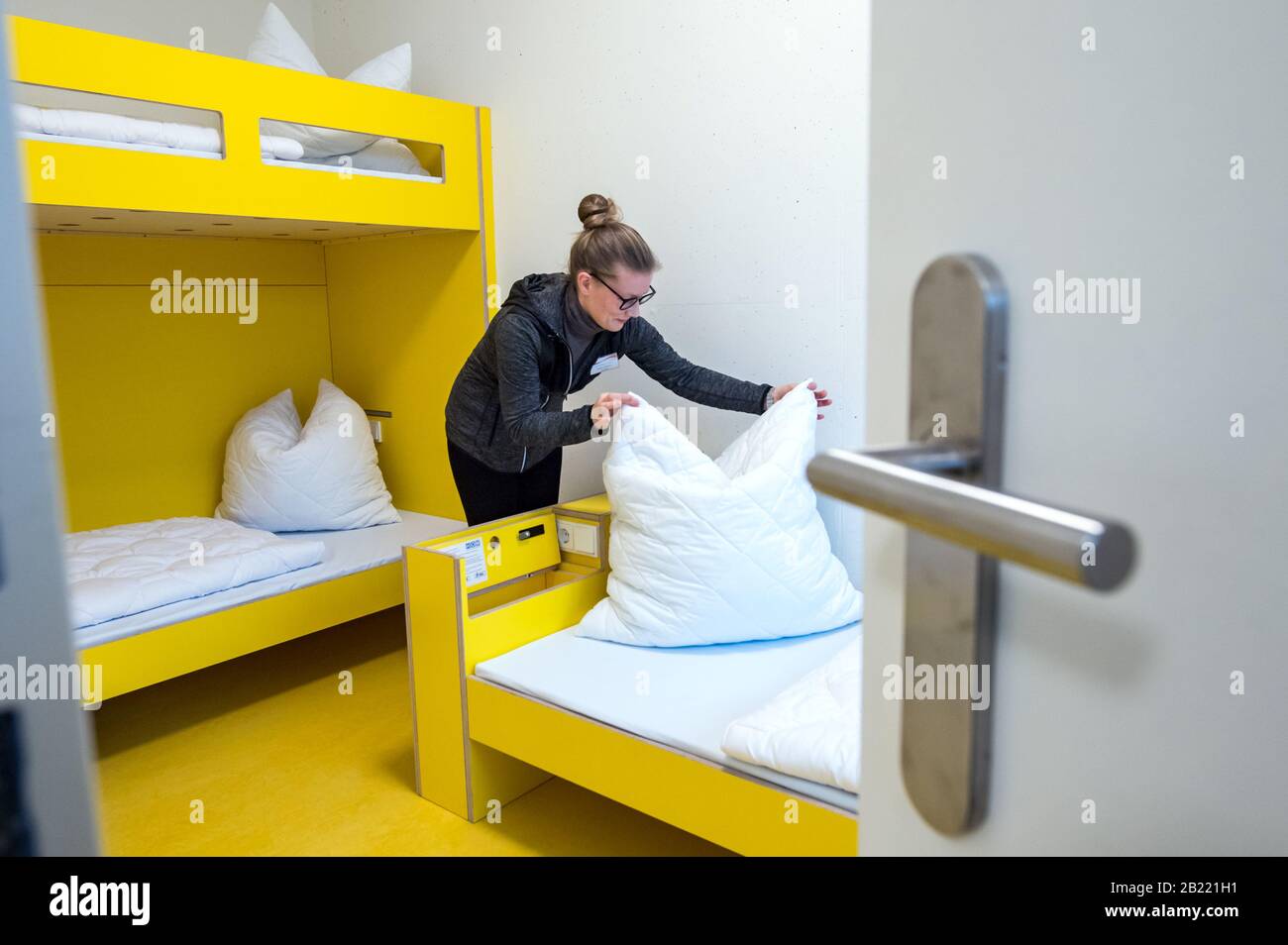 26 février 2020, Saxe, Schöneck: Un employé de la nouvelle auberge de jeunesse établit les lits dans une chambre d'hôtes du bâtiment moderne. Le nouveau bâtiment avec 40 chambres et 136 lits se compose de trois maisons qui sont reliées les unes aux autres. Une grande salle de conférence ou des salles de vélos, de skis et de snowboards sont à la disposition des clients. Photo: Hendrik Schmidt/dpa-Zentralbild/ZB Banque D'Images