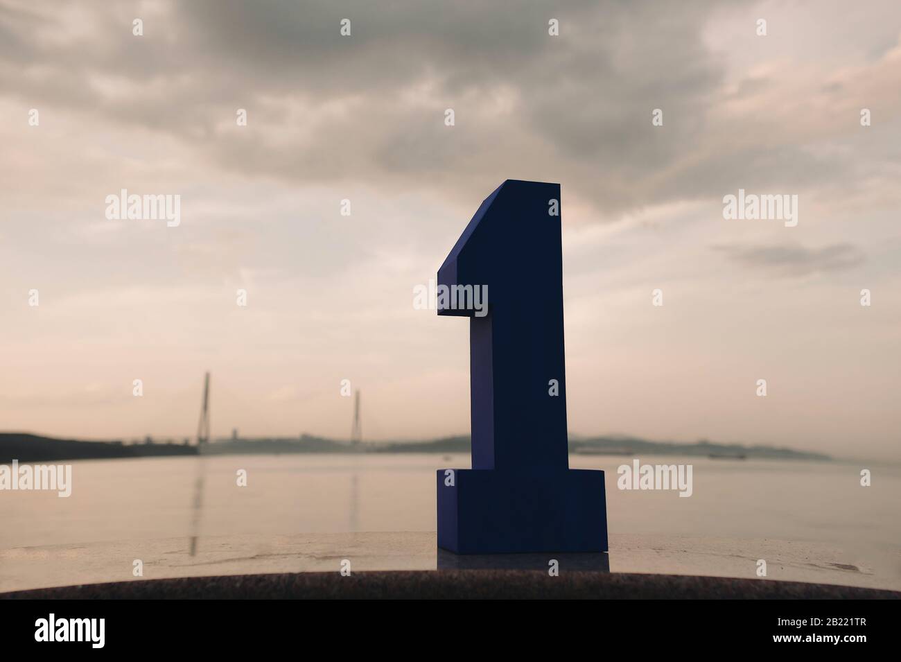 Grand carton bleu numéro un sur l'arrière-plan du pont de câble en Russie la ville de Vladivostok et la mer au coucher du soleil Banque D'Images