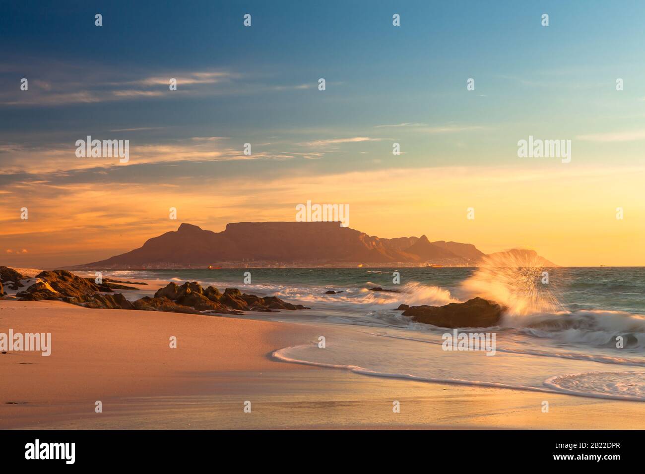 vue panoramique sur la montagne de la table au coucher du soleil dans le cap blouberg afrique du sud avec des vagues éclaboussant Banque D'Images
