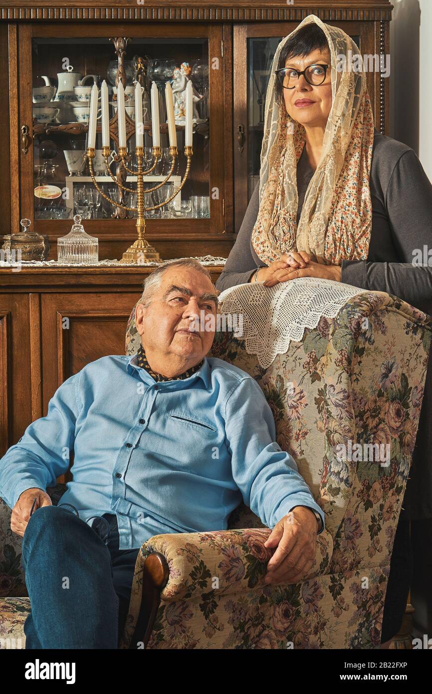 Un couple juif senior pose sur un fauteuil dans une maison traditionnelle Banque D'Images