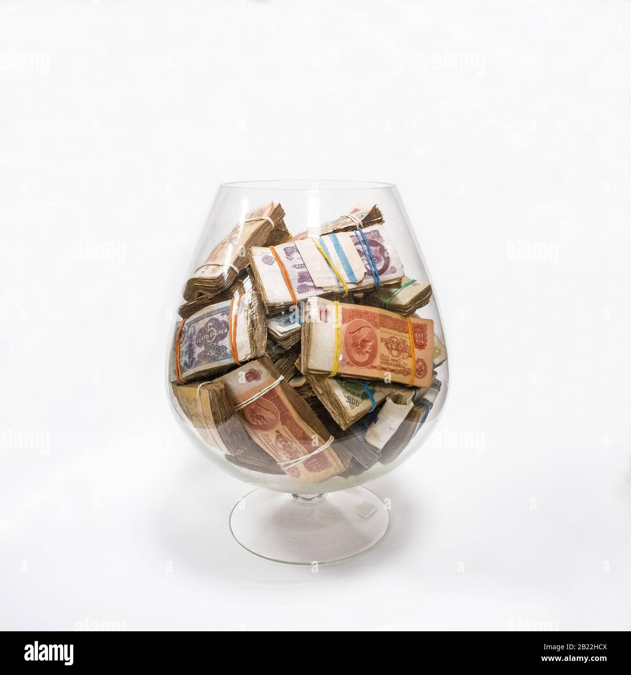Paquets d'argent soviétique de l'échantillon de 1961 dans un grand vase en verre sur fond blanc. Banque D'Images