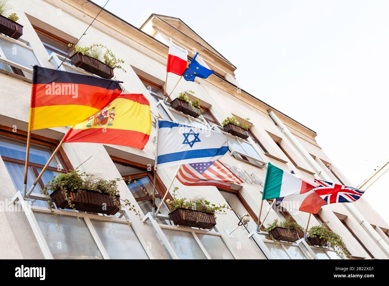 Plusieurs drapeaux agitant sur une façade de bâtiment au vent, Israël, Allemagne, Espagne, États-Unis, Pologne, Union européenne, Italie, France, Royaume-Uni, de nombreuses nations Banque D'Images