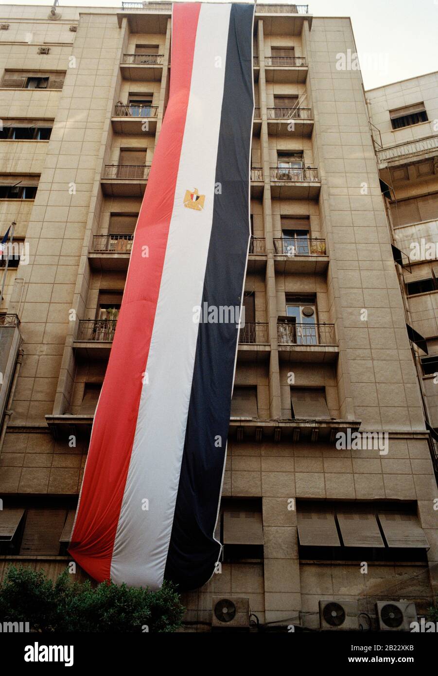 Photographie de voyage - le drapeau égyptien vole d'un bâtiment dans le centre-ville du Caire en Egypte en Afrique du Nord Moyen-Orient Banque D'Images