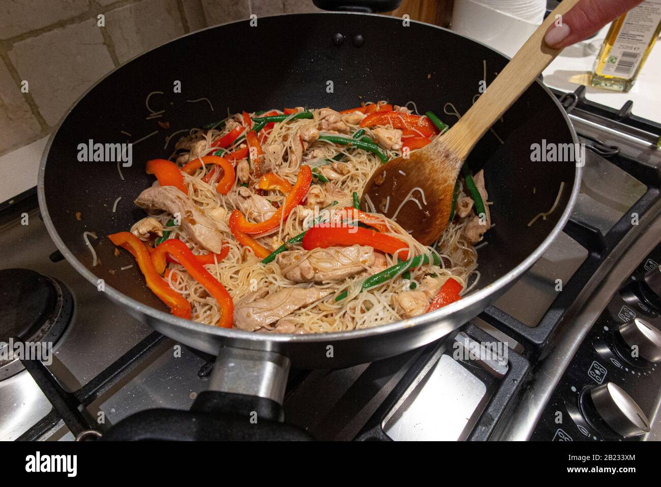Cuisine asiatique dans un wok sur une table de cuisson au gaz Photo Stock -  Alamy