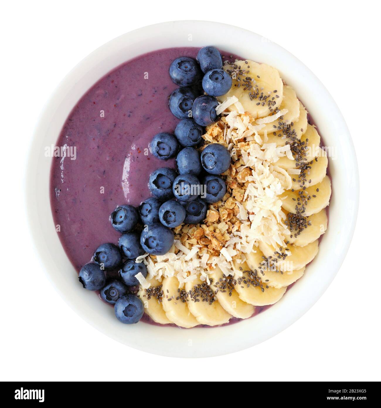 Bol à smoothie sain aux bleuets avec noix de coco, bananes, graines de chia et granola isolé sur un fond blanc Banque D'Images